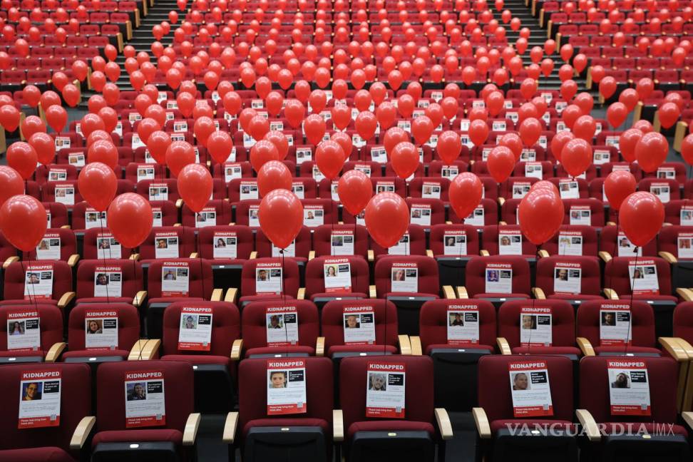 $!Fotografías de 224 rehenes israelíes y globos rojos están adheridas a los asientos en el teatro del Centro Internacional de Convenciones en Jerusalén, Israel.