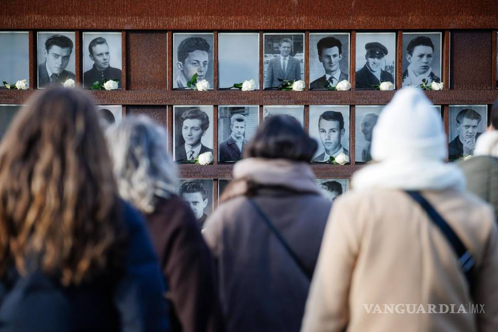 $!Visitantes observan retratos adornados con rosas de las víctimas del Muro de Berlínen Berlín, Alemania.