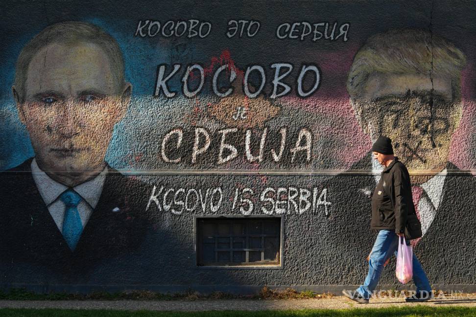 $!Un hombre pasa junto a un grafiti que dice “Kosovo es Serbia” y que muestra a Vladimir Putin y a Donald Trump, vandalizados con pintura, en Belgrado, Serbia.