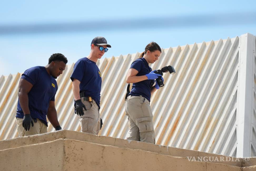 $!Agentes del orden investigan el techo de un edificio de apartamentos cerca de la escena de un tiroteo en una oficina del ICE en Dallas.