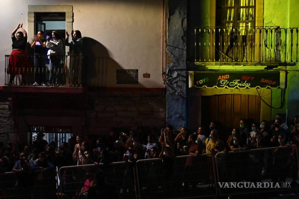 $!Personas intentan observar la inauguración del Festival Cervantino mientras en un balcón un grupo de mujeres bailan con la música de Los Vam Vam. Cuartoscuro/Daniel Augusto