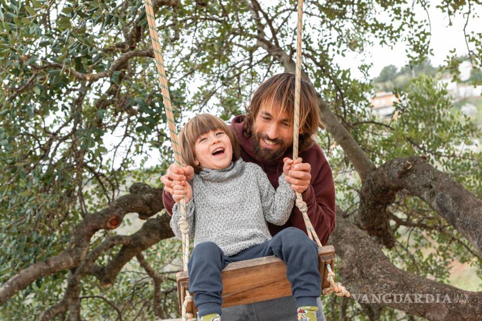 $!Padre columpiando a su hijo pequeño en un parque.