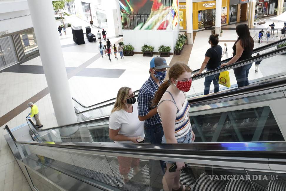 $!Imagen del 29 de mayo de 2020, personas con cubrebocas toman una escalera mecánica hasta el segundo piso del Arden Fair Mall en Sacramento, California.