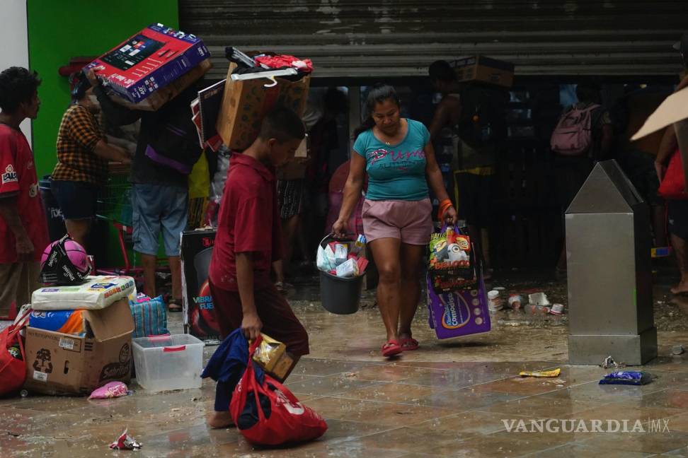 $!La gente saquea una tienda de comestibles después de que el huracán Otis arrasara Acapulco, Guerrero (México).