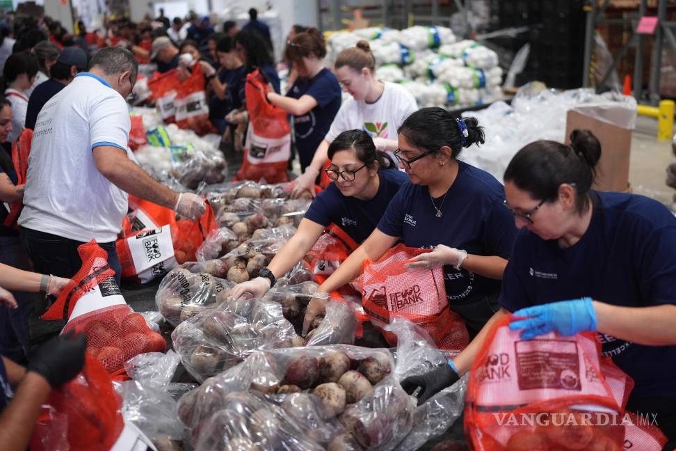 $!Voluntarios del Banco de Alimentos de San Antonio cargan bolsas de papas para una distribución de alimentos a beneficiarios del programa SNAP en San Antonio.