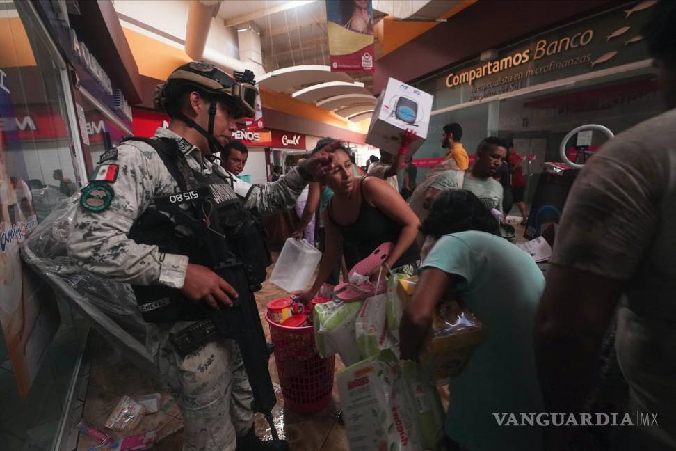 $!Un militar de la Guardia Nacional intenta impedir que personas se lleven productos de las tiendas de un centro comercial en Acapulco, Guerrero (México).