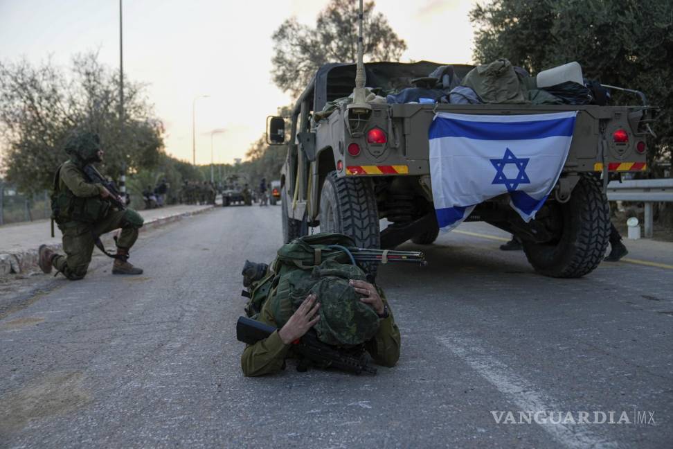 $!Un soldado israelí piensa erróneamente que se activó una alarma de ataque aéreo y se echa al suelo para cubrirse, en el kibutz Be'eri, en Israel.