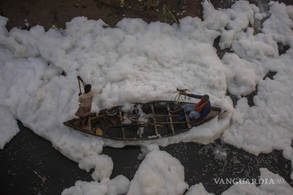 $!Un hombre navega en su bote de remos sobre el río Yamuna, cubierto de espuma química causada por la contaminación industrial y doméstica, durante el festival Chhath Puja en Nueva Delhi. AP/Altaf Qadri