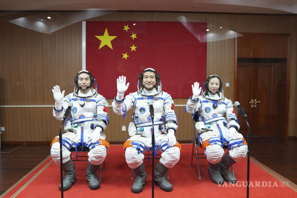 $!En esta foto publicada por la Agencia de Noticias Xinhua, los astronautas chinos de izquierda a derecha, Ye Guangfu, Zhai Zhigang y Wang Yaping saludan desde detrás del panel de vidrio antes de partir hacia su misión espacial con tripulación Shenzhou-13 en el Centro de Lanzamiento de Satélites de Jiuquan en el noroeste de China. AP/Li Gang/Xinhua