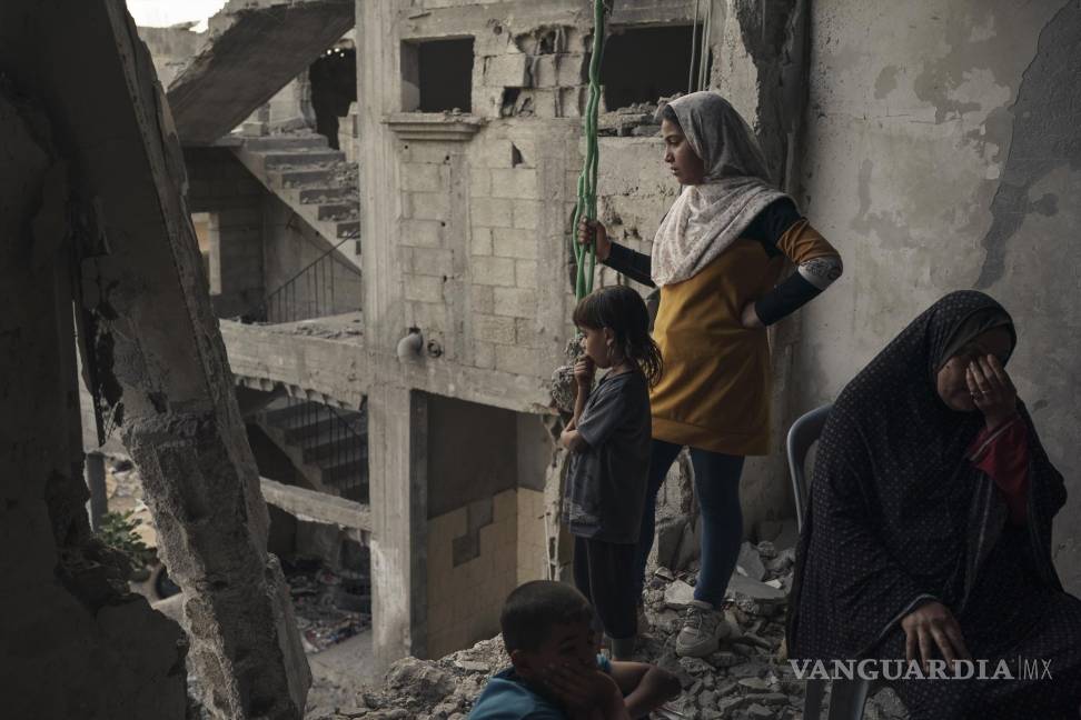 $!Miembros de la familia Nassir se sientan en su casa, muy dañada por los ataques aéreos en Beit Hanoun, en el norte de la Franja de Gaza, el viernes 11 de junio de 2021. AP/Felipe Dana