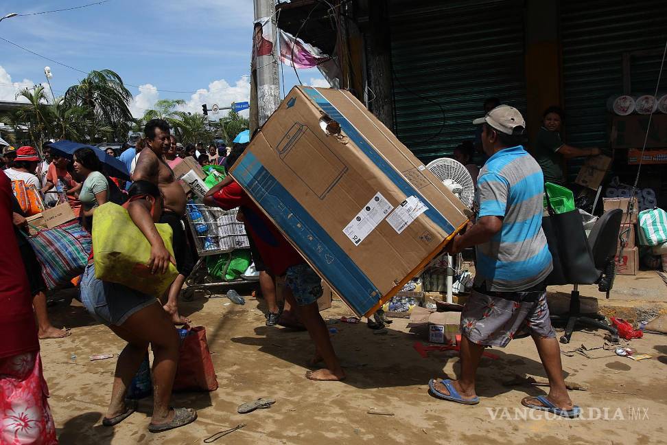$!Fotografía que muestra personas mientras saquean tiendas de autoservicio por el paso del huracán Otis en el balneario de Acapulco, Guerrero (México).