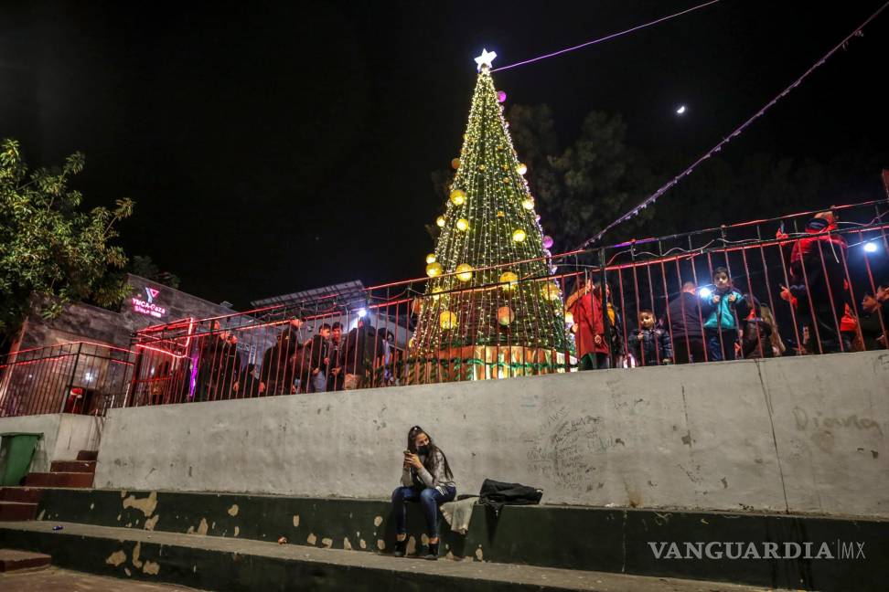 $!Una mujer sentada cerca de un árbol de Navidad en la ciudad de Gaza. EFE/EPA/Mohammed Saber