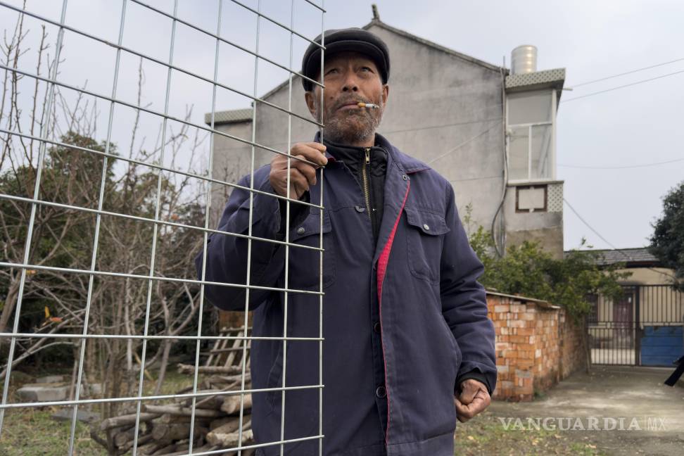 $!Yang Guoliang de pie en la puerta delante de su casa en Changzhou, en la provincia oriental china de Jiangsu.