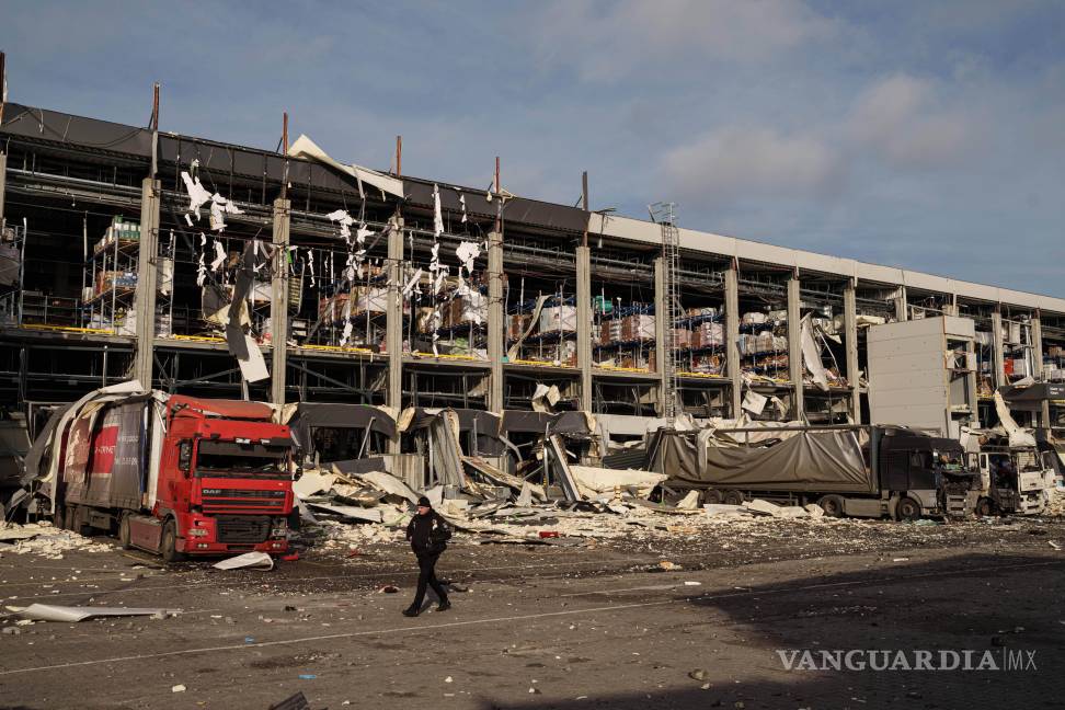 $!Un agente de policía camina frente a un centro logístico de Novus dañado tras un ataque ruso en Kiev, Ucrania.