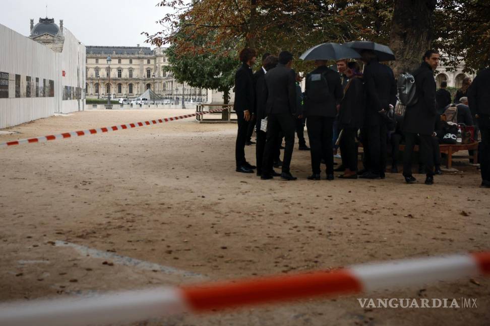 $!Empleados esperan después de la evacuación del Museo de Louvre en París, el sábado 14 de octubre de 2023.