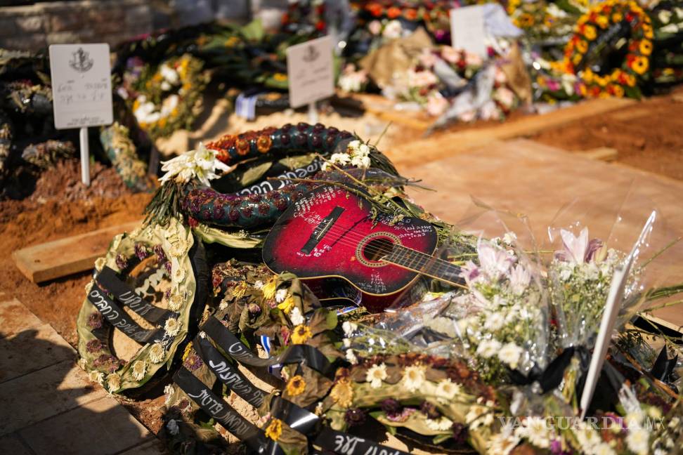 $!Una guitarra y coronas de flores en la tumba del soldado Ilai Azar tras su funeral en el cementerio de Kiryat Shaul en Tel Aviv, Israel, el 14 de octubre de 2023.