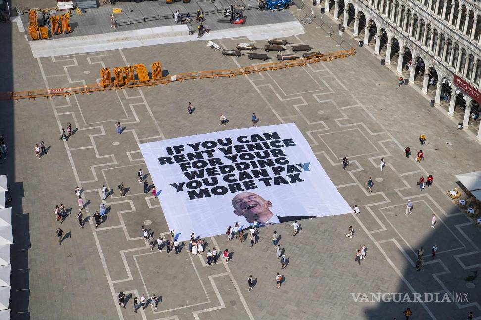 $!Activistas de Greenpeace despliegan una pancarta gigante con la imagen deJeff Bezos, que dice ‘Si puedes alquilar Venecia para tu boda, puedes pagar más impuestos’ en la Plaza de San Marcos en Venecia.