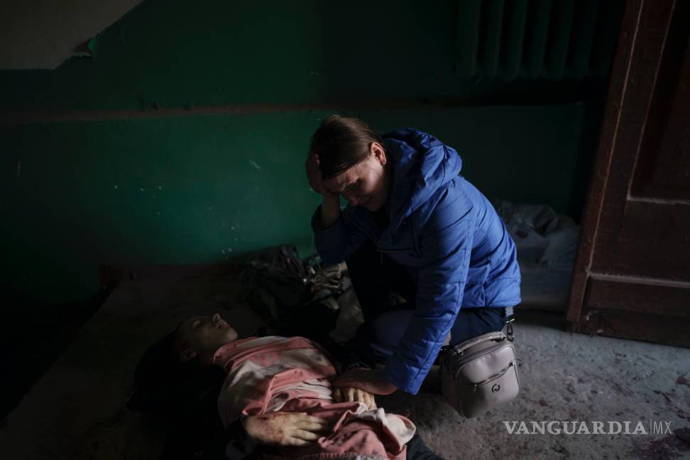 $!Nina Shevchenko llora sobre el cuerpo de su hijo de 15 años, Artem Shevchenko, asesinado en un ataque ruso en Járkiv, Ucrania, el viernes 15 de abril de 2022.