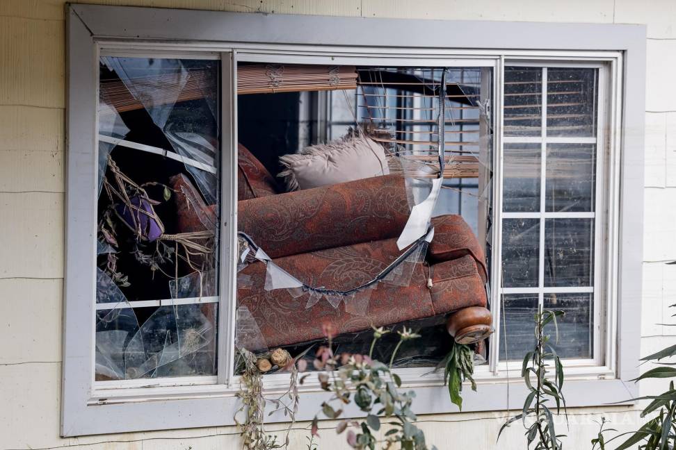 $!Un sofá atravesó las ventanas delanteras de una casa después de las catastróficas inundaciones causadas por la tormenta tropical Helene en Swannanoa.