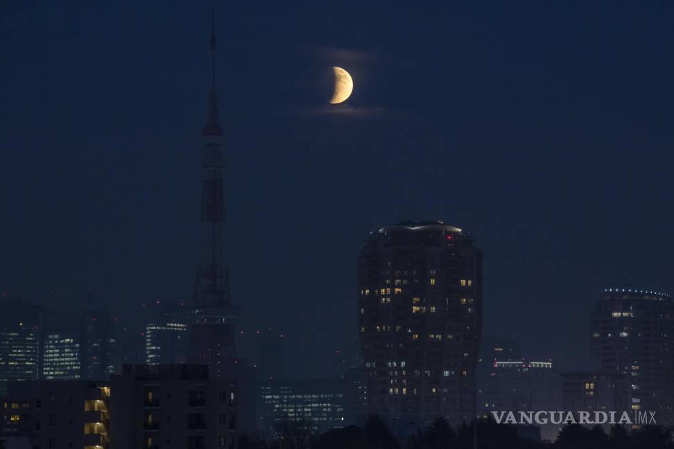 $!Un eclipse lunar parcial sobre la Torre de Tokio se asoma detrás de las nubes en Tokio. AP/Kiichiro Sato