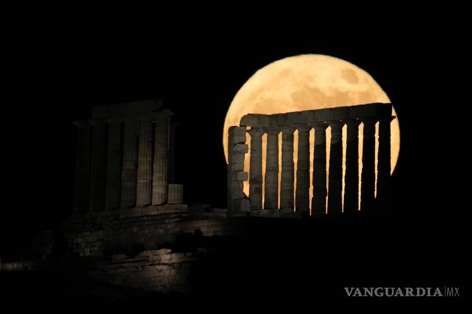 $!La luna llena de fresas se eleva detrás del antiguo templo de Poseidón en el cabo Sounion al sur de Atenas, Grecia.