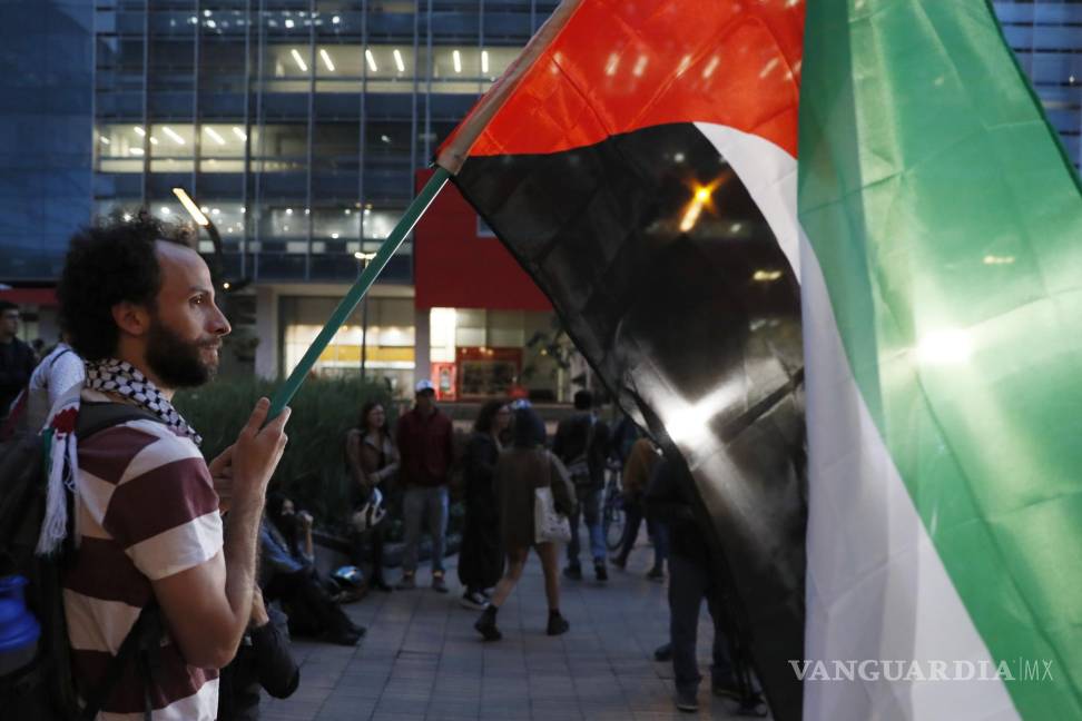 $!Un hombre sostiene una bandera de Palestina en una manifestación de apoyo a Palestina frente a la embajada de Israel en Bogotá, Colombia.