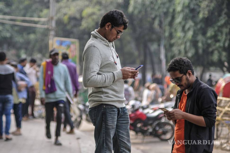 $!Dos personas revisan sus celulares en la Universidad de Dhaka, Bangladesh. Con un deepfake, la imagen de un candidato se puede distorsionar o suavizar.