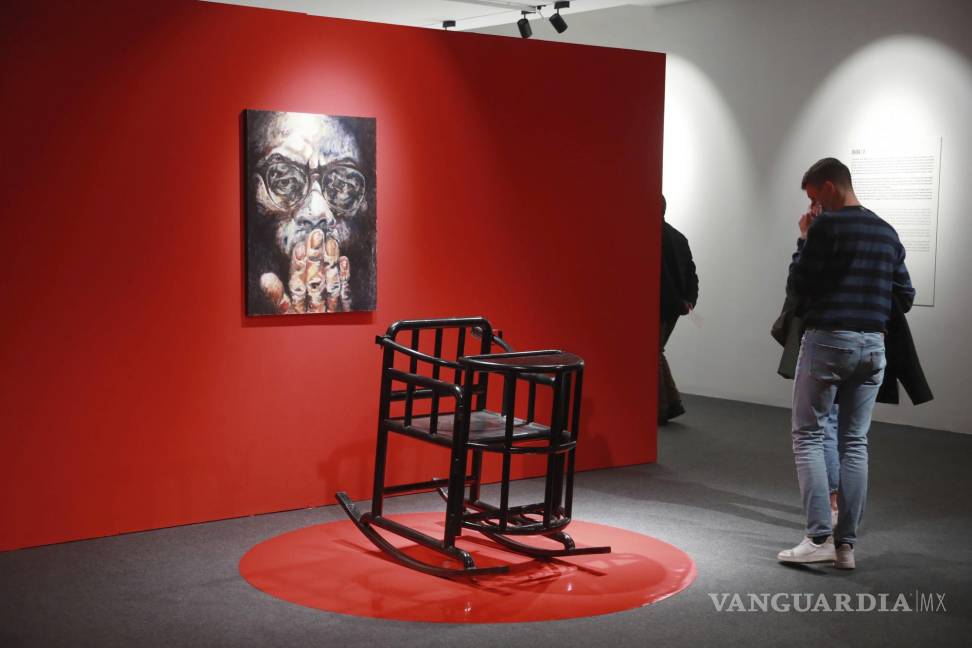 $!Personas caminan frente a una silla de tortura durante la inauguración de la exhibición de Badiucao en el Museo Santa Giulia en Brescia, Italia. AP/Felice Calabro