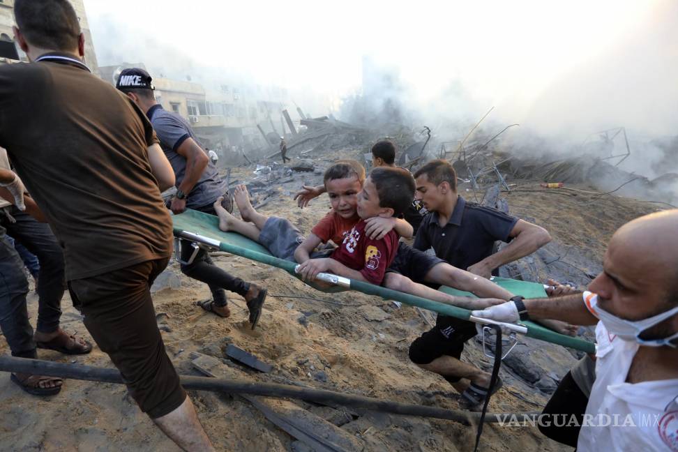 $!Palestinos sacan a dos niños heridos en un ataque aéreo israelí sobre la Ciudad de Gaza, el 25 de octubre de 2023.