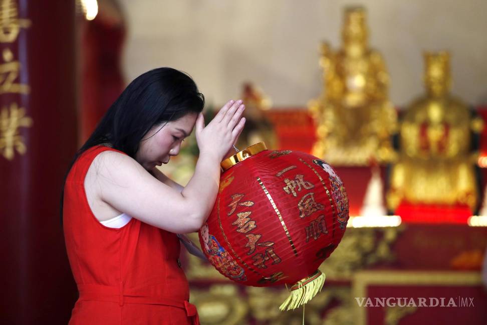 $!Una mujer reza por buena fortuna junto a los dioses chinos para conmemorar el Año Nuevo Lunaren Chinatown, Bangkok, Tailandia.