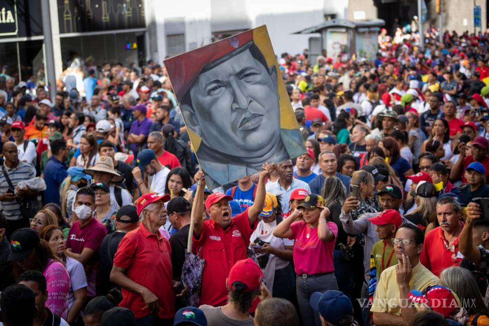 $!Un hombre carga un cuadro con la imagen del expresidente fallecido Hugo Chávez durante una marcha adepta al gobierno de Nicolás Maduro en Caracas, Venezuela.