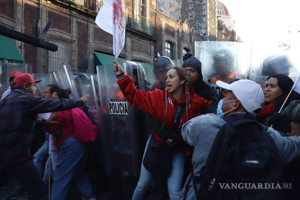 $!Integrantes de la CNTE intentaron derribar una de las vallas que protegían los accesos a Palacio Nacional lo que provocó una confrontación con la policía.