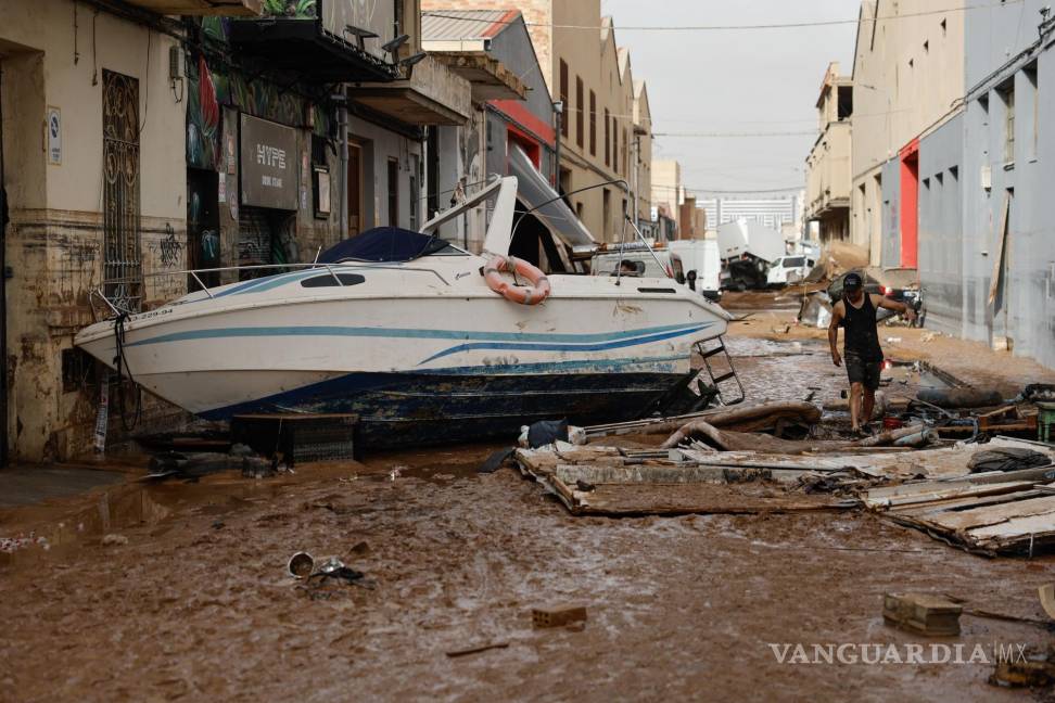 $!Vehículos amontonados en una calle tras las intensas lluvias de la fuerte DANA en Sedaví, Valencia.