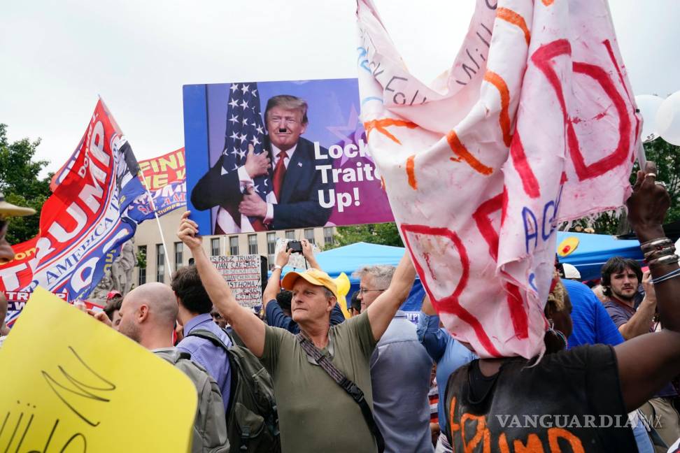 $!Eric Lamar sostiene un cartel contra Trump mientras está rodeado de manifestantes y simpatizantes del expresidente Donald Trump en Washington.