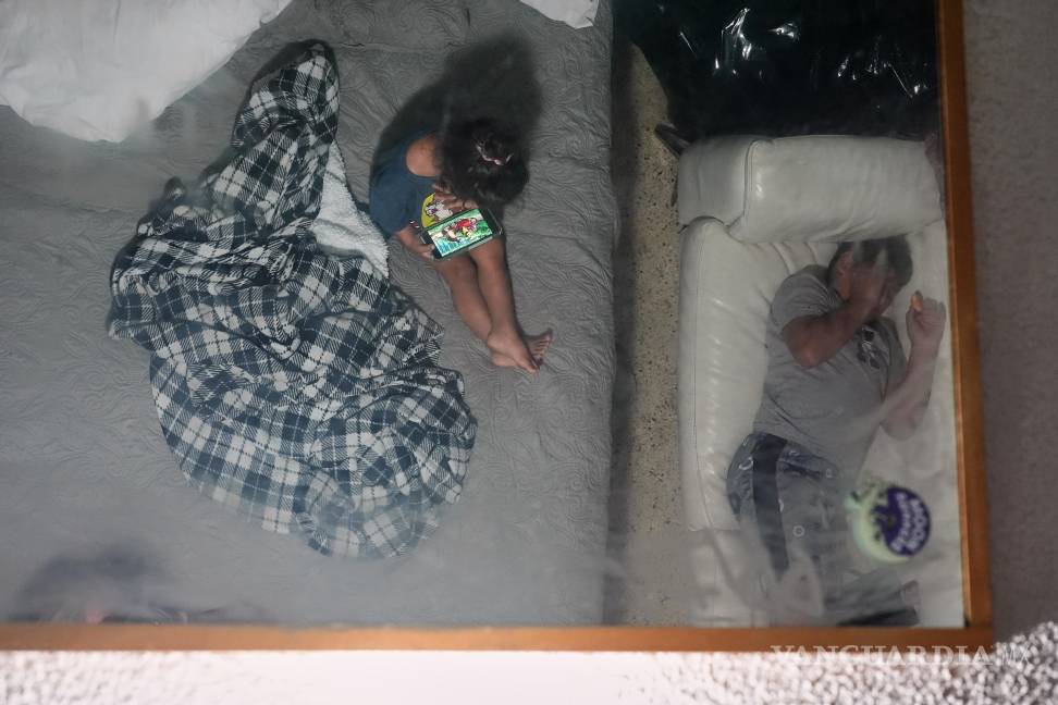 $!Imagen de dos hermanos se refleja en el espejo del techo de la habitación de motel donde viven en Miami con su madre, luego de que su padre fue deportado.