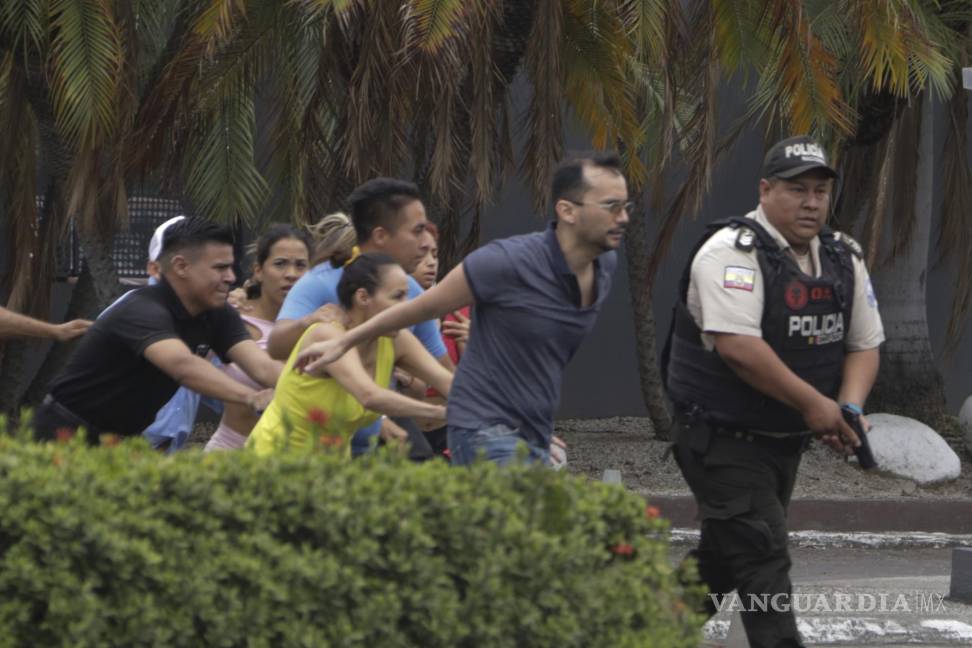 $!La policía evacúa a personal del canal TC Televisión después de que un grupo armado y encapuchado irrumpiera en plena transmisión en directo, en Guayaquil.