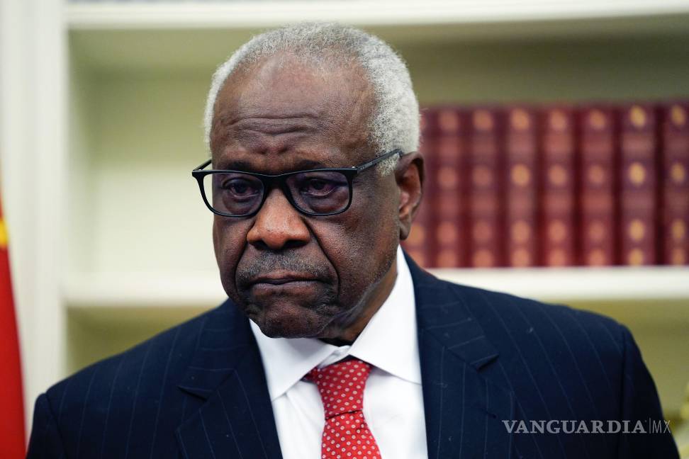 $!El juez asociado de la Corte Suprema Clarence Thomas escucha al presidente Donald Trump.