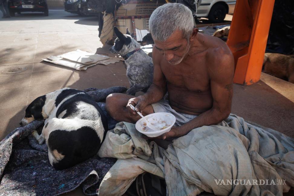 $!Un hombre come en una calle, en el centro de la ciudad, en Sao Paulo (Brasil).