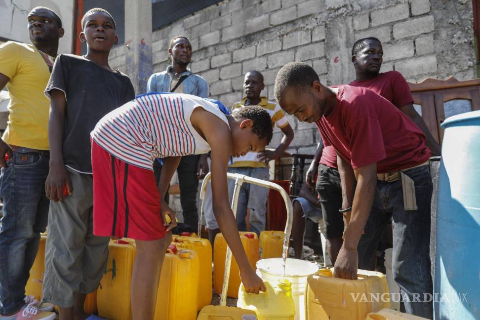 $!Residentes llenan garrafas con agua potable, en Puerto Príncipe, Haití, el 8 de marzo de 2024.
