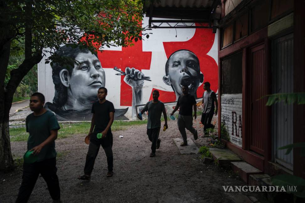 $!Estudiantes de primer año pasan por delante de un mural dedicado a los 43 compañeros desaparecidos de la escuela Normal Rural Raúl Isidro Burgos.