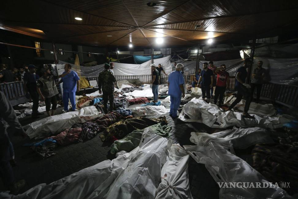 $!Cuerpos de palestinos muertos por una explosión en el hospital árabe Ahli están reunidos en el patio delantero del hospital al-Shifa, en la ciudad de Gaza.