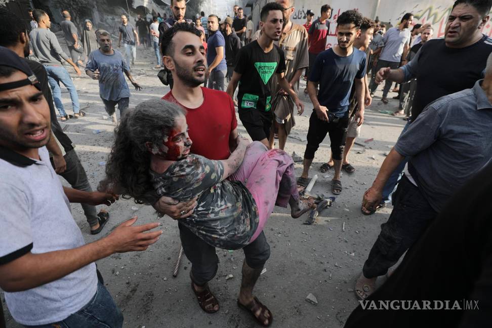 $!Un hombre lleva a una niña herida tras los ataques aéreos israelíes en el norte de Gaza.