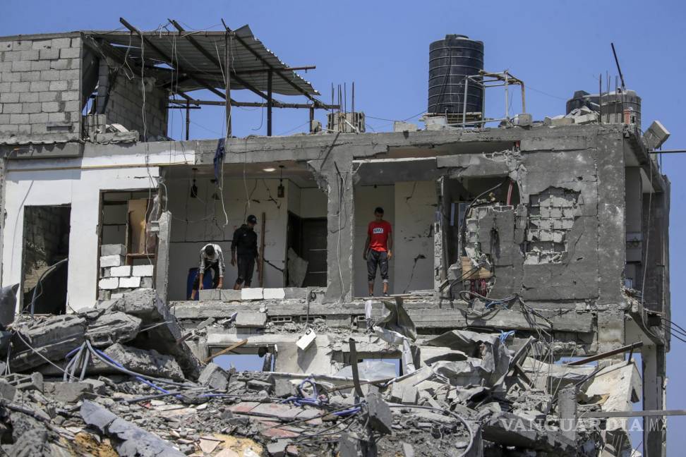 $!Varios palestinos inspeccionan sus casas destruidas en el campo de refugiados de Al Maghazi, en el centro de la Franja de Gaza, tras los ataques aéreos israelíes.