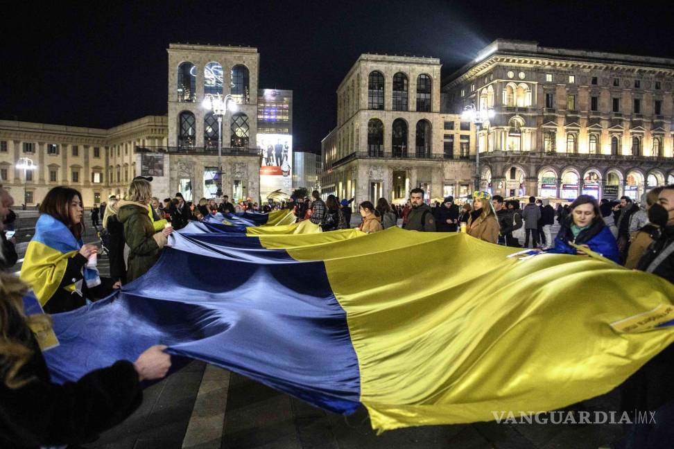 $!La gente lleva una enorme bandera ucraniana durante una protesta contra la agresión rusa a Ucrania, en Milán, Italia. EFE/EPA/Andrea Fasani