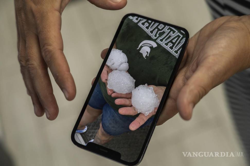 $!El gerente de una tienda de Denha &amp; Sons, Inc. muestra una foto de granizo del tamaño de una pelota de béisbol durante una tormenta en Davison, Michigan.