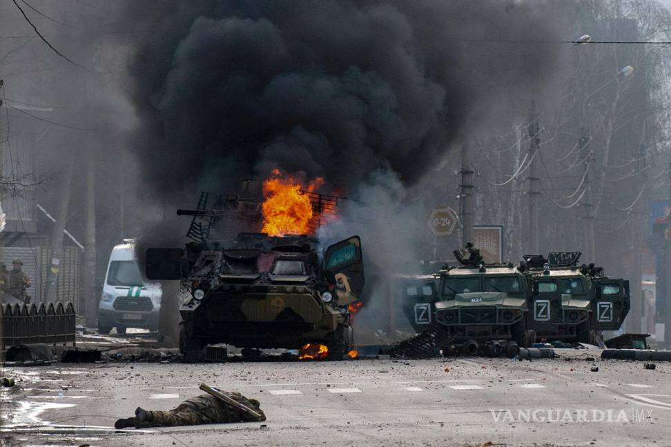 $!Un vehículo blindado ruso de transporte de personal arde en medio de vehículos ligeros dañados y abandonados tras combates en Járkiv, Ucrania.