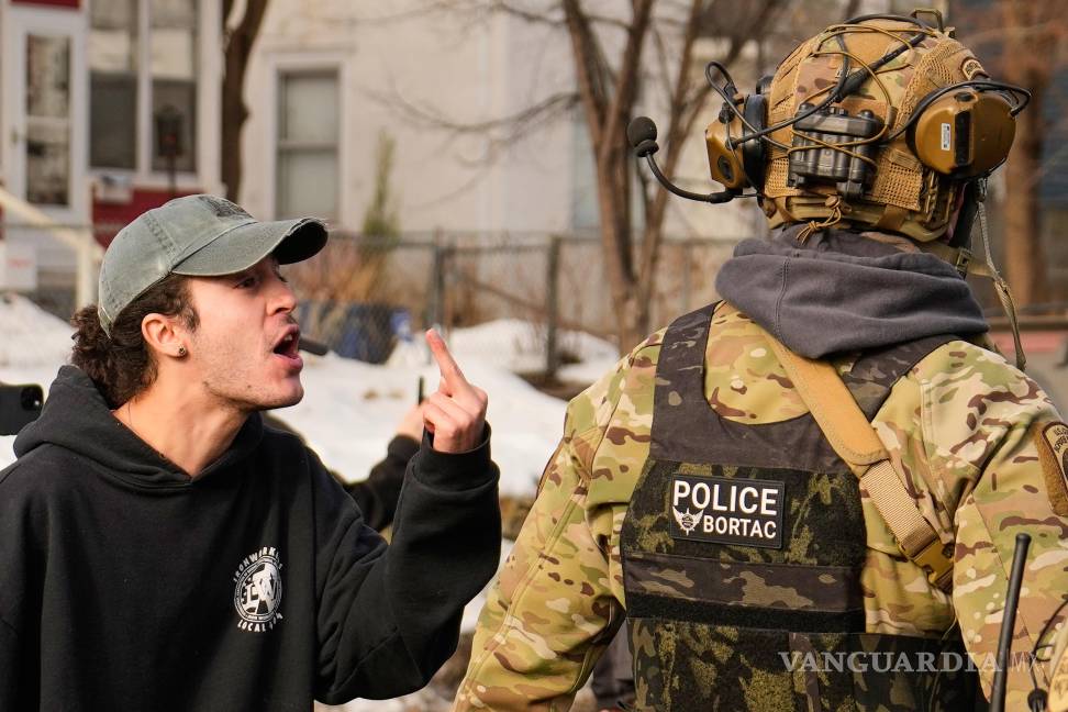 $!Un manifestante le hace un gesto a un agente federal de inmigración el lunes 12 de enero de 2026 en Minneapolis.
