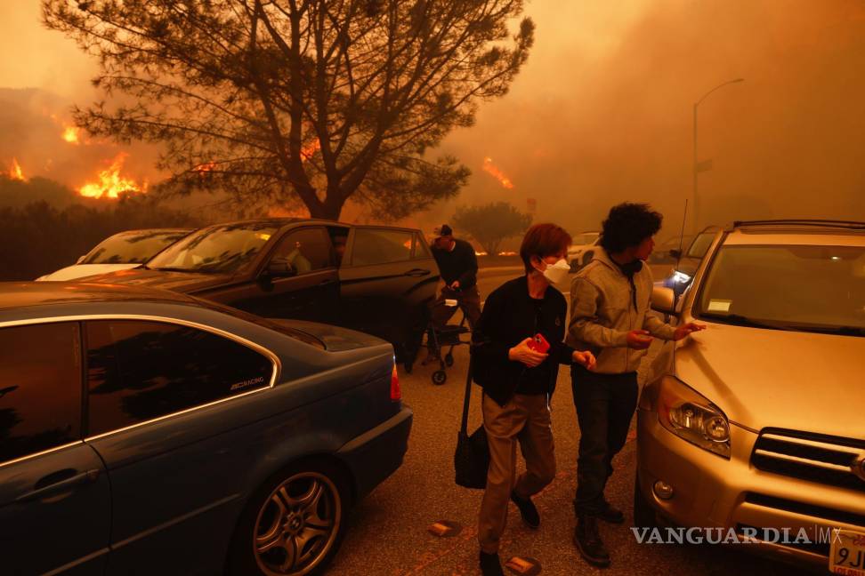 $!La gente huye del avance del incendio Palisades, en automóvil y a pie, en el vecindario Pacific Palisades de Los Ángeles.