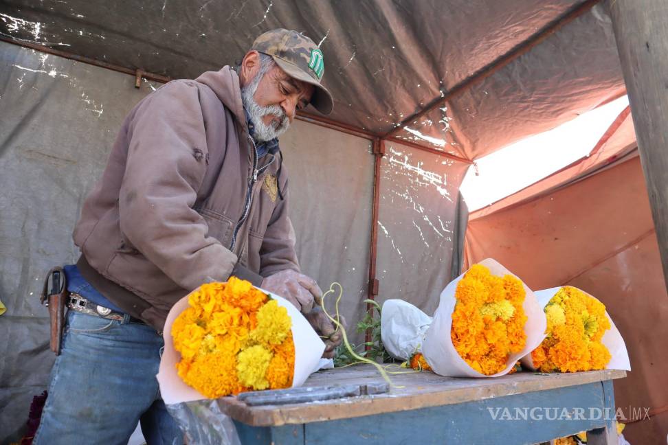 $!Miguel Núñez, comerciante de flores, se prepara para atar ramos de cempasúchil.