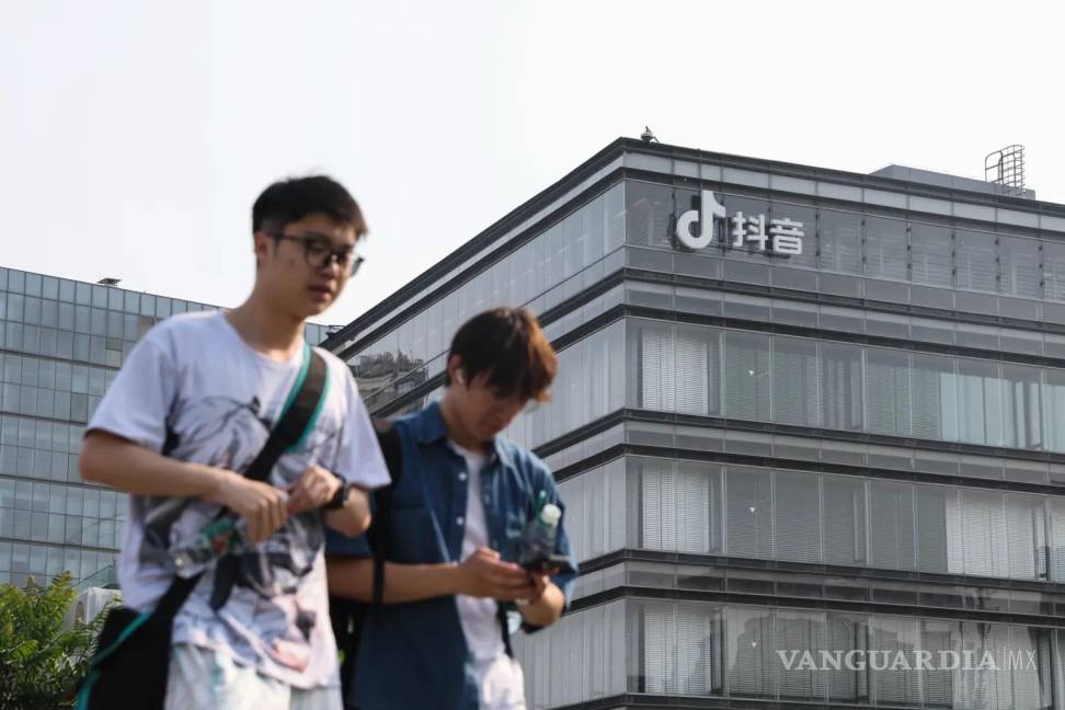 $!Dos jóvenes caminan frente a las oficinas de ByteDance, matriz de TikTok, en Pekín, China.